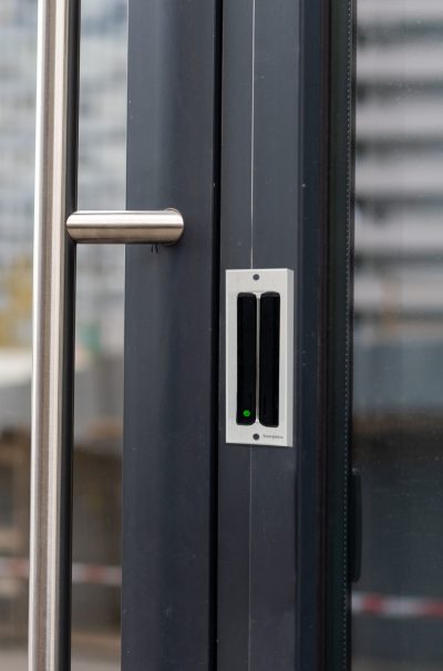 The front door of a office block, reflecting buildings in the glass.